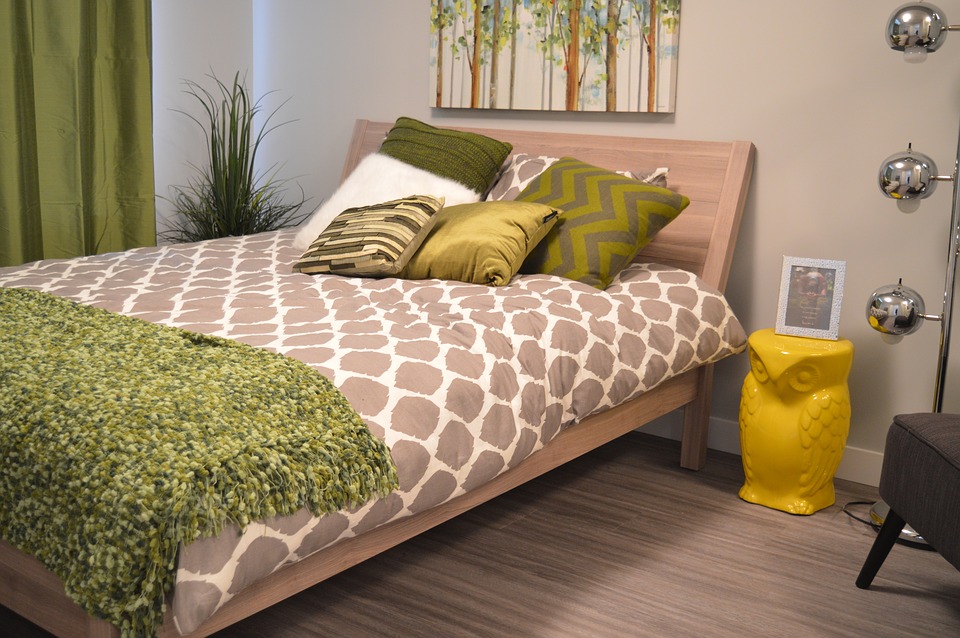 Lys seng med grønt tæppe og grønne puder