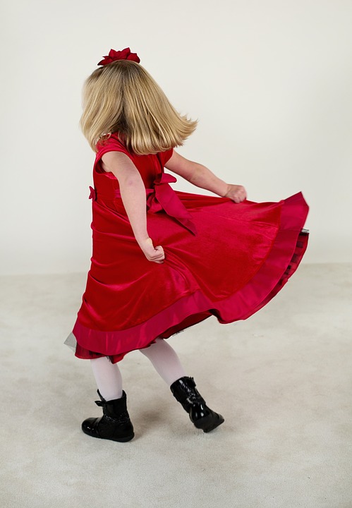 Lille pige i rød kjole der danser